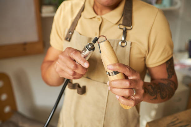 istock Tattooed female jeweler using tools 1447464084