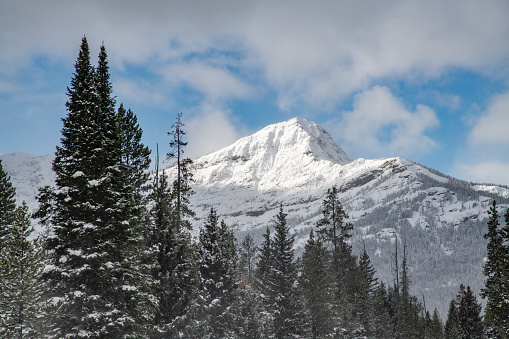 Snow capped mountain peak and clouds near Cooke City, Montana on the edge of northeastern Yellowstone National Park, USA.