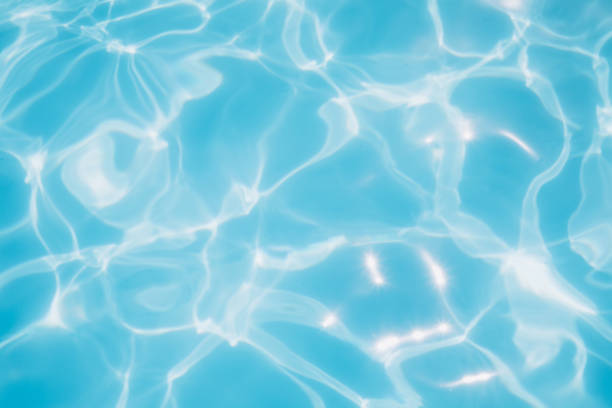 istock Background, blue water waves in the pool with sun reflection, selective focus 1447467099