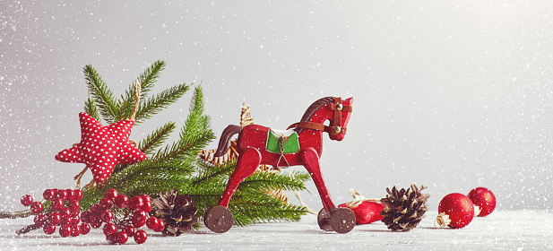 Christmas card with vintage wooden horse decoration for tree and garland at old board