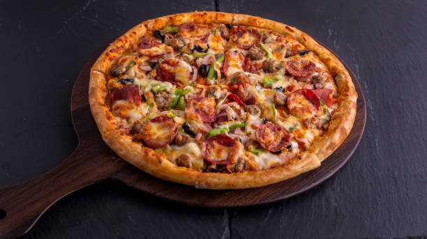 beef supreme pizza aislada en la vista superior de la tabla de cortar sobre fondo oscuro comida rápida italiana - pizza de chorizo fotos fotografías e imágenes de stock