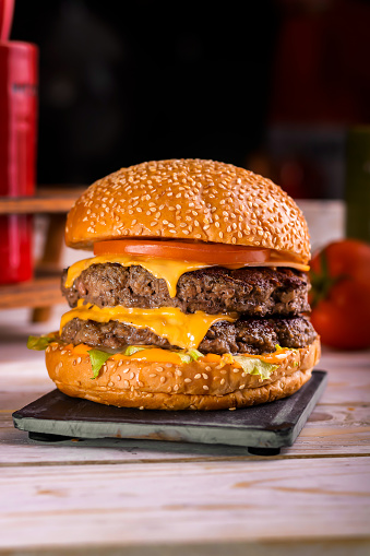 Angus Beef Double burger isolated on cutting board top view on dark background american fast food