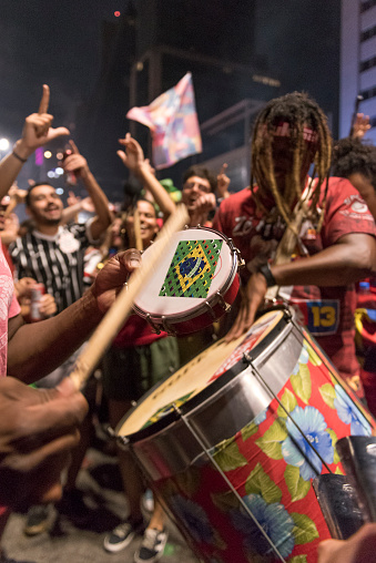 São Paulo, SP, Brazil - October 30, 2022: Closeup of a man's hands holding a drumstick and tambourine during an event on Paulista Avenue