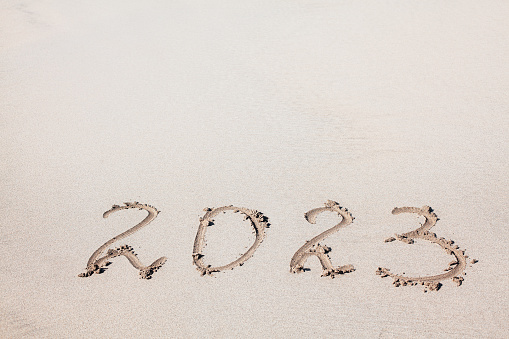 New Year 2023 on the sand . Handwritten in the sand