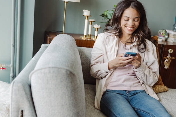 istock Young woman using mobile phone at home. Scrolling through social media 1447482983