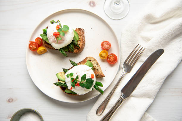 Poached eggs on toast with avocado, asparagus, tomatoes and sprout for healthy breakfast