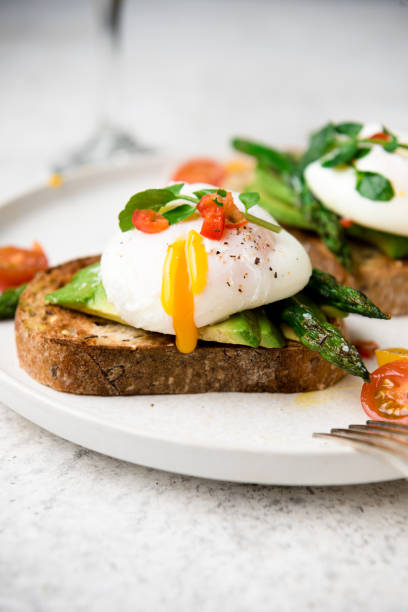 istock Poached eggs on toast with avocado, asparagus, tomatoes and sprout for healthy breakfast 1447483041