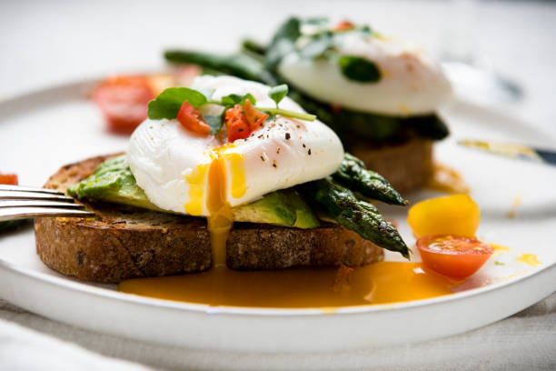 istock Poached eggs on toast with avocado, asparagus, tomatoes and sprout for healthy breakfast 1447483059
