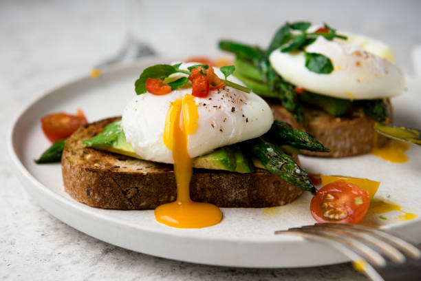 건강한 아침 식사를 위해 아보카도, 아스파라거스, 토마토, 새싹을 곁들인 토스트에 수란을 얹습니다. - poached egg 뉴스 사진 이미지