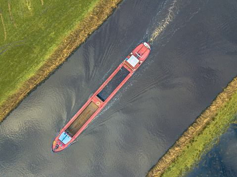 Moving Inland freight ship Aerial top down view  in dutch canal