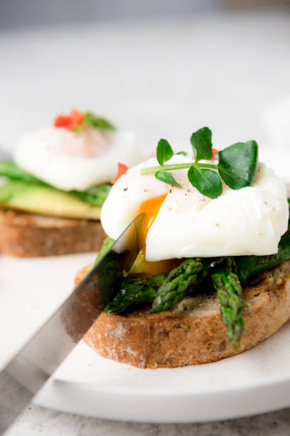 istock Poached eggs on toast with avocado, asparagus, tomatoes and sprout for healthy breakfast 1447483165
