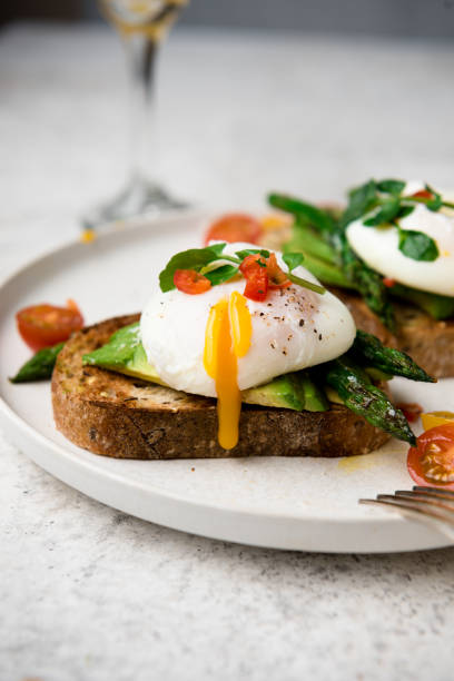 istock Poached eggs on toast with avocado, asparagus, tomatoes and sprout for healthy breakfast 1447483230