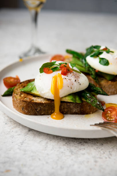 istock Poached eggs on toast with avocado, asparagus, tomatoes and sprout for healthy breakfast 1447483272