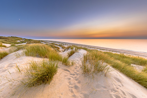 Sunset View over ocean from dune over North Sea and Canal in Ouddorp, Zeeland Province, the Netherlands. Outdoor scene of coast in nature of Europe.