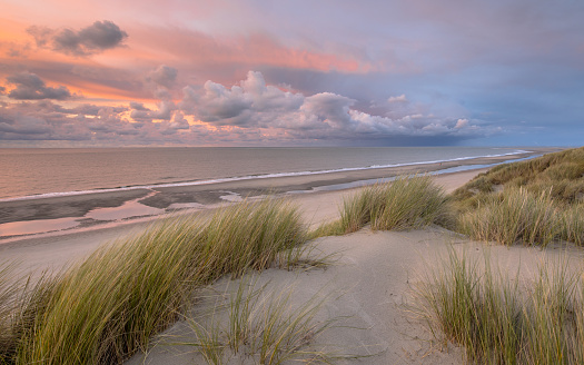 Wide angle view over sunset over the sand dunes at Barmouth Beach, Gwynedd, Wales, UK.