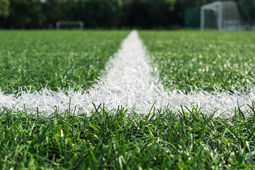 Green artificial grass turf soccer football field background.