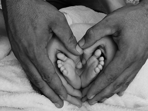 Baby's feet and parent's hands