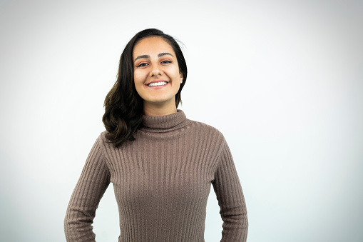 Close up portrait of young adult middle eastern woman with white background.