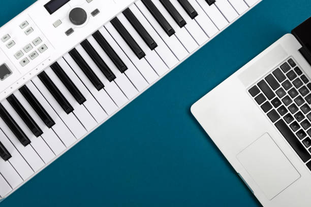 istock Music keys and laptop on a blue background, flat lay, copy space. 1447487017