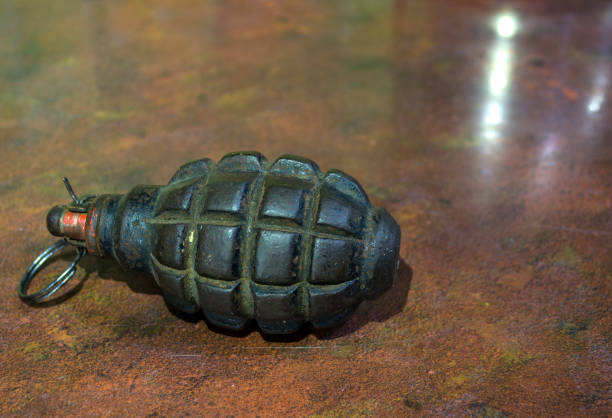 Fragmentation grenade with hole, on camouflage clothing. High quality photo