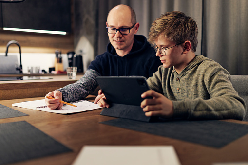 Father and teenage son doing some homework together. The father is helping son with his math lessons.
Shot with Canon R5
