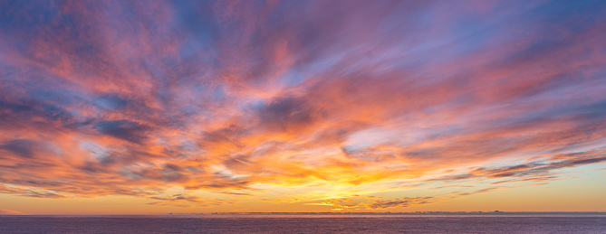 Sunset sky with orange clouds and blue background skies