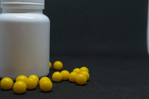Vitamins and a white jar on a dark background. High quality photo