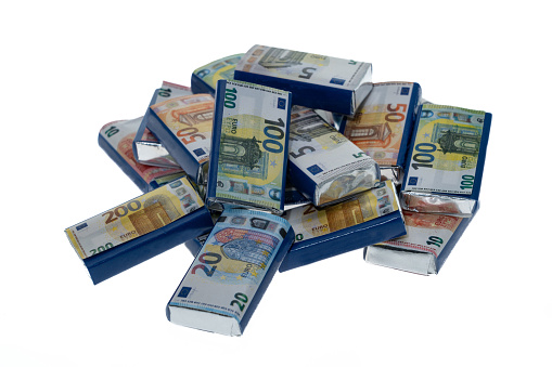 Small bars of chocolate wrapped in Euro currency banknotes - white background