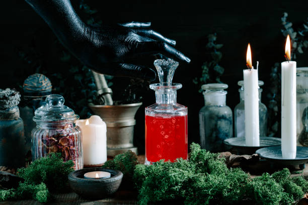 istock black witch hand opening magic potion, herbs ingredients candles and magical equipment 1447506017