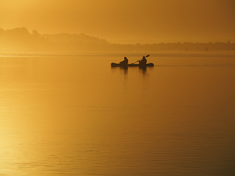Kayakers in silhouette in golden sunset