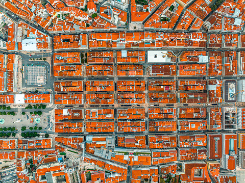 Overhead top down birds eye aerial view of patterns of red rooftops of traditional houses with narrow streets in Lisbon city center