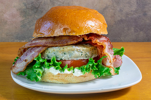 chicken burger top with hickory bacon between a brioche bun