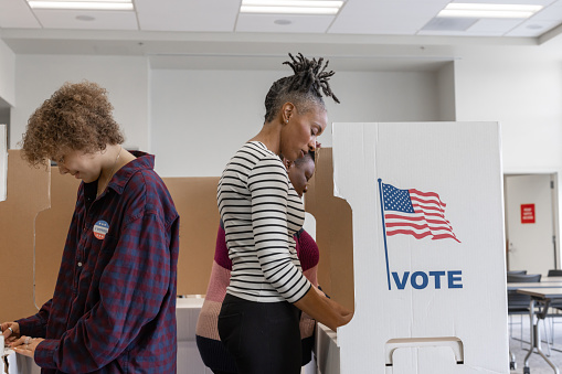 An African American woman voting at a local community center.