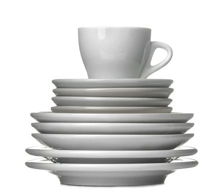 A stack of dishes. Dinnerware. plates and cup on a white isolated background. close-up.