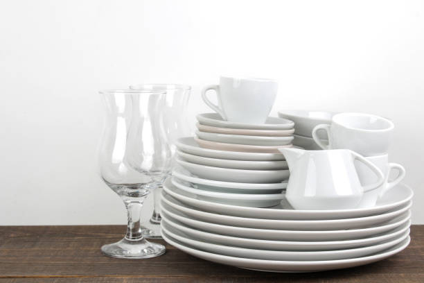 istock A stack of dishes. tableware on a brown wooden table. dishes for serving the table. plates and cutlery, cups and teapot, glasses. 1447524806
