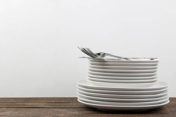 istock A stack of dishes. tableware on a brown wooden table. plates and cutlery. with space for text 1447524812