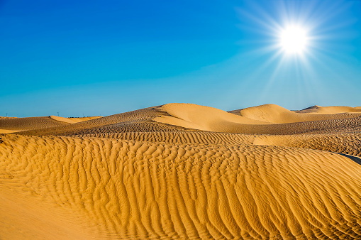 Tunisian desert landscape with blue sky. Dunes background