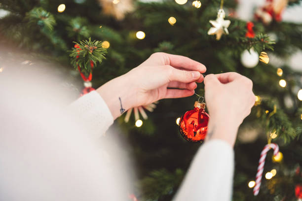 istock Unrecognizable woman hands decorating the Christmas tree with red ornaments 1447527838