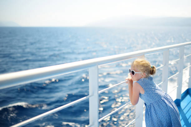 Adorable young girl enjoying ferry ride staring at the deep blue sea. Child having fun on summer family vacation in Greece. Adorable young girl enjoying ferry ride staring at the deep blue sea. Child having fun on summer family vacation in Greece. Kid sailing on a boat. ferry deck girls stock pictures, royalty-free photos & images