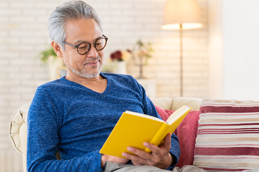 Asian elderly man who reads a book,