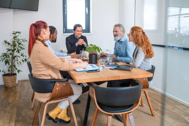 istock Young Asian Businessman Smiling At a Multiracial Colleagues While Seated 1447535451