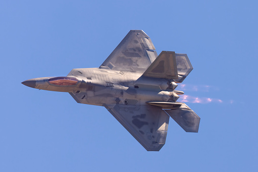 F-22 Raptor in a turn in beautiful light ,  with afterburners on