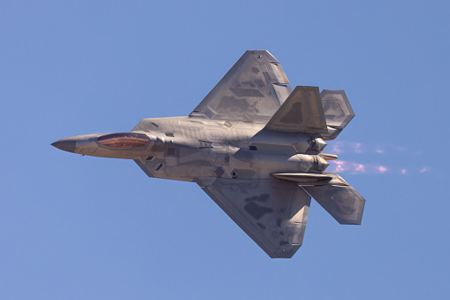 F-22 Raptor in a turn in beautiful light ,  with afterburners on