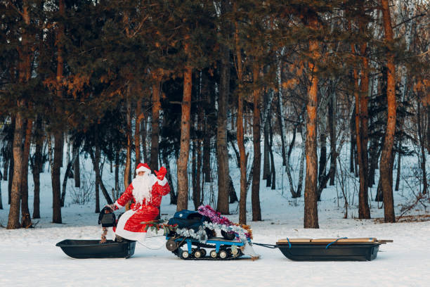 istock Santa claus riding snowmobile in the winter forest 1447540112