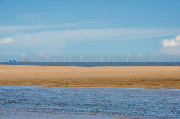 istock Blue sky, white clouds, sea, beach, and some wind power on the sea 1447542478