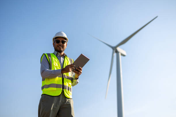 istock Engineer India man working with tablet at windmill farm Generating electricity clean energy. Wind turbine farm generator by alternative green energy. Asian engineer checking control electric power 1447546479