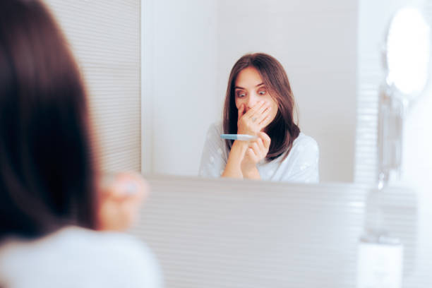 istock Happy Woman Checking Pregnancy Test in the Bathroom 1447548890