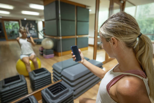 istock Woman using phone in the gym 1447549301