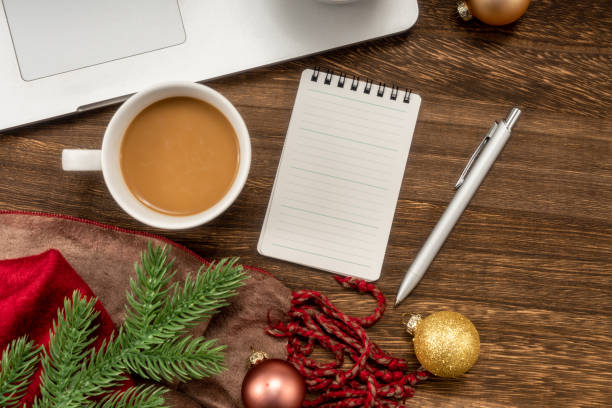 istock Laptop and notepad with ornaments balls on wood table. 1447555120
