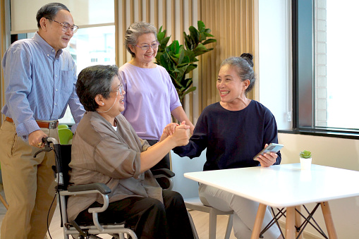 Happy cheerful Asian elder people sitting in living room and talking together, a long friendship or relationship in people concept. Group of senior elder person meeting and talking.